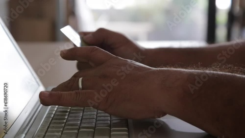 Businessman's hand with financial charts and mobile phone over a laptop on the table
