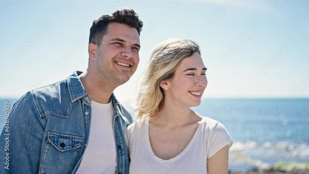 Man and woman couple smiling confident standing together at seaside Man and woman couple smiling confident standing together at seaside