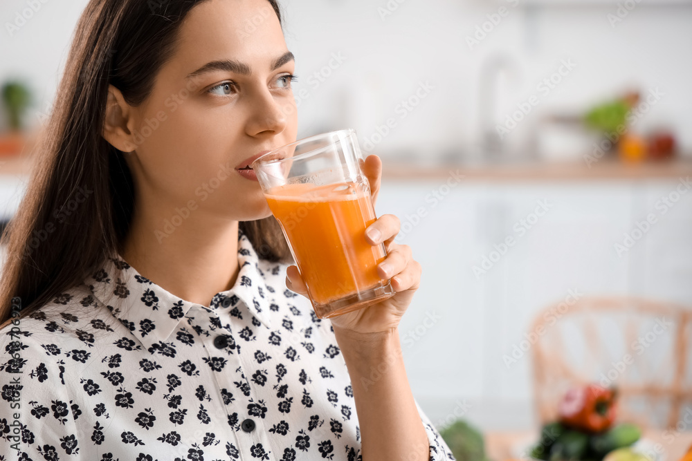 Young woman drinking vegetable juice in kitchen, closeup Young woman drinking vegetable juice in kitchen, closeup
