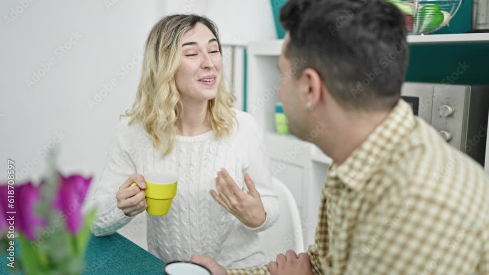 Man and woman couple sitting on table drinking coffee at dinning room Man and woman couple sitting on table drinking coffee at dinning room