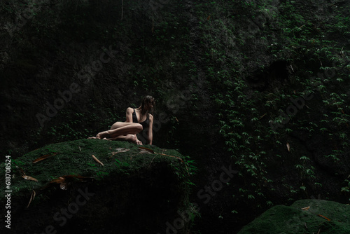 girl in a sexy bikini near a waterfall in the tropical jungle