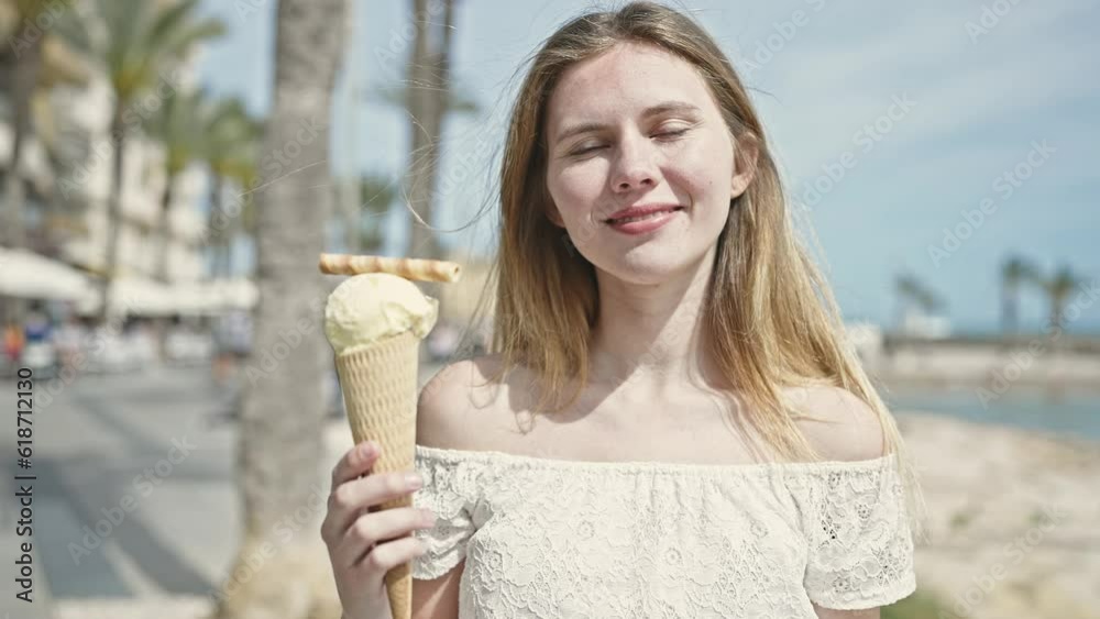 Young blonde woman tourist smiling confident holding ice cream at seaside Young blonde woman tourist smiling confident holding ice cream at seaside