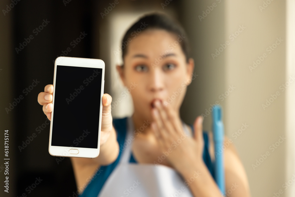 Modern Connectivity, Young excited and surprised Asian Woman, Low-Paid Cleaner Worker, Holding Blank Smartphone, Embracing Technology in Urban Life