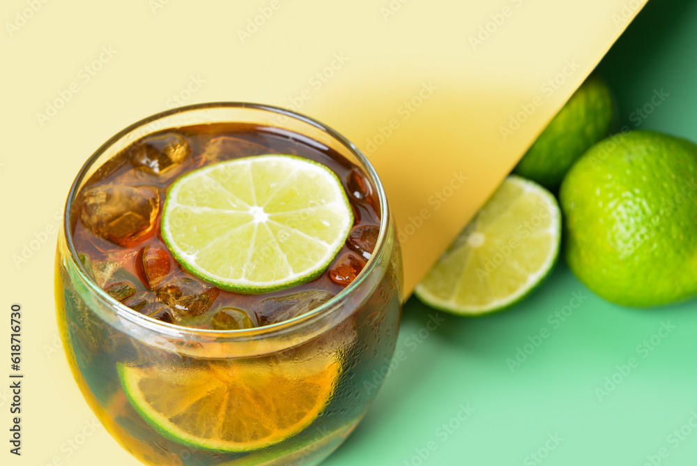 Glass of cold Cuba Libre cocktail on color background Glass of cold Cuba Libre cocktail on color background