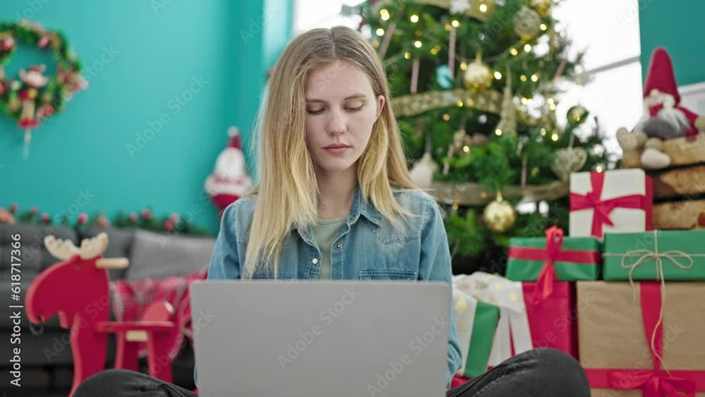 Young blonde woman using laptop celebrating christmas at home Young blonde woman using laptop celebrating christmas at home