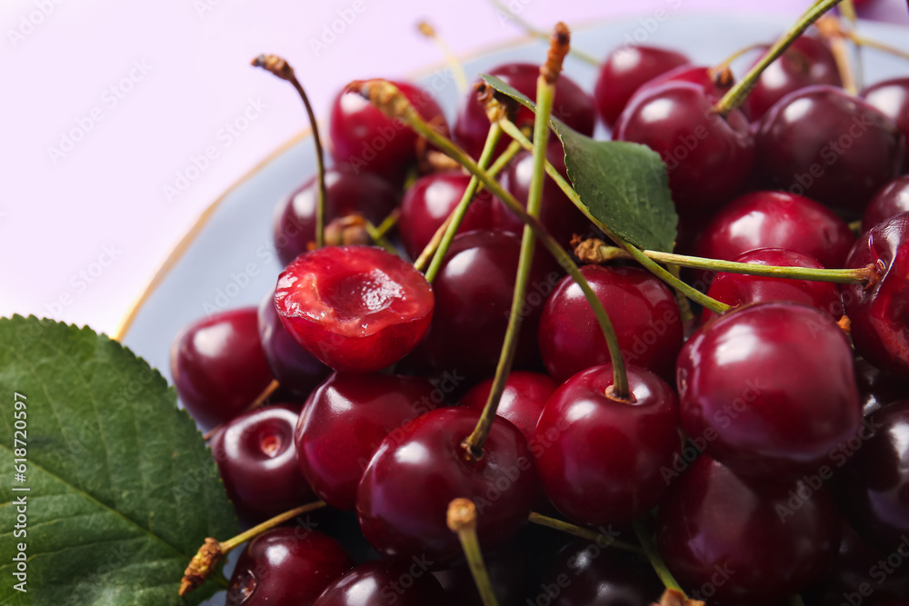 Plate with sweet cherries and leaves, closeup Plate with sweet cherries and leaves, closeup
