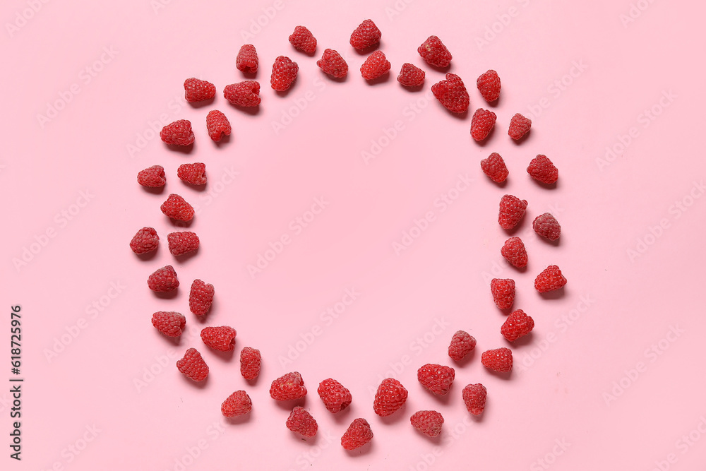 Frame made of fresh raspberries on pink background Frame made of fresh raspberries on pink background