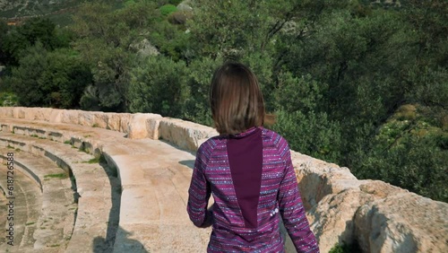 Girl impressed in ancient greek theatre in Turkey. 4k video footage UHD 3840x2160 photo