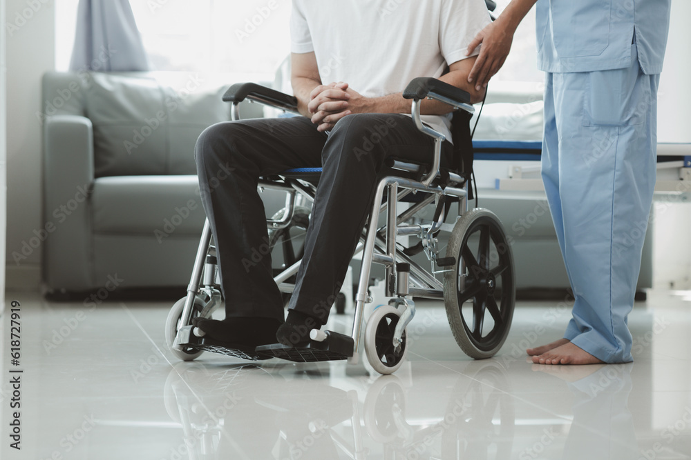 Obraz premium Male patient sitting in wheelchair undergoing a medical examination with specialist physician, treating injuries Getting medical treatment from specialist doctor can get the right and proper treatment