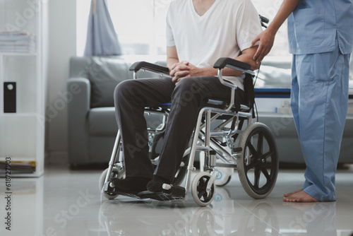 Male patient sitting in wheelchair undergoing a medical examination with specialist physician, treating injuries Getting medical treatment from specialist doctor can get the right and proper treatment