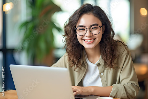 Portrait of happy beautiful woman using handphone and computer at office, creative working