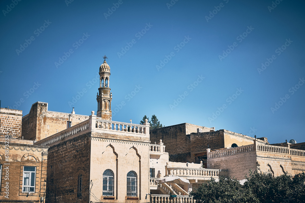 Belltower of Bethil Church and terraces and roofs of traditional buildings at Midyat. Architecture of Midyat city, Mardin province, Turkey