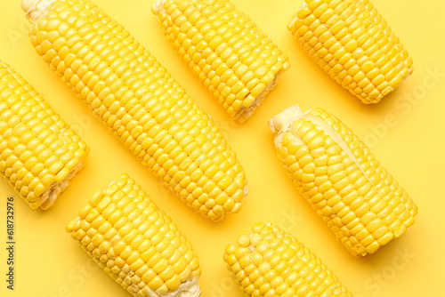 Fresh corn cobs on yellow background