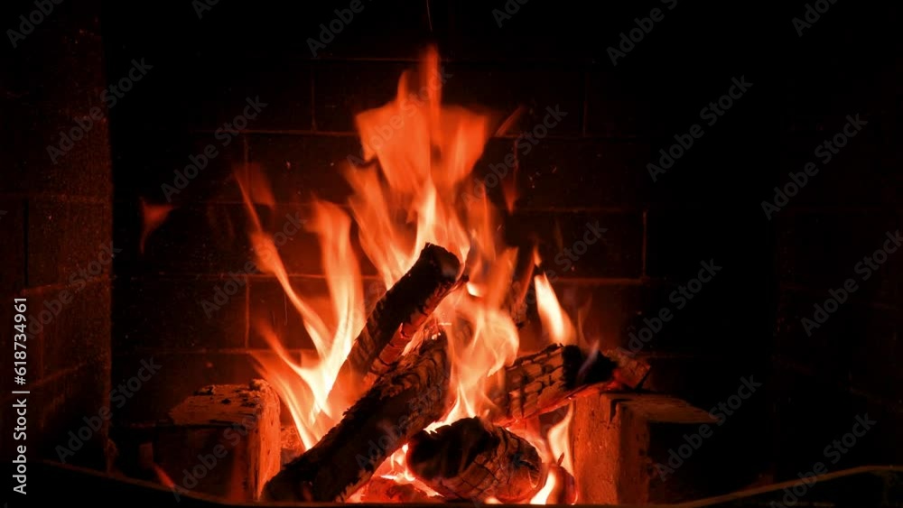 Home fireplace with red flame and firewood. 4K video relaxing endless footage