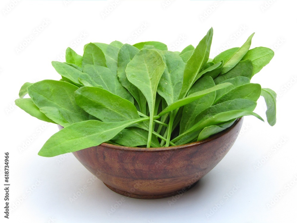 Fresh green Spinach leaves in a wooden bowl on white background Fresh green Spinach leaves in a wooden bowl on white background