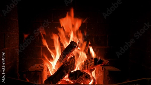 Home fireplace with red flame and firewood. 4K video relaxing endless footage