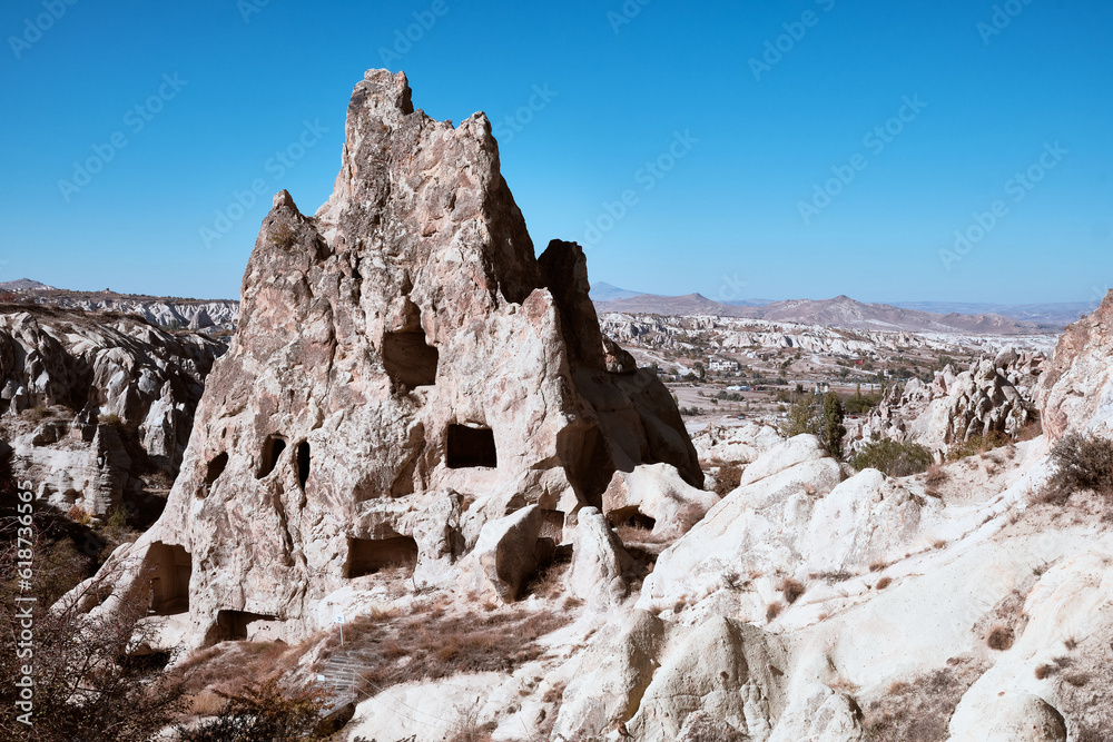 Ancient cave dwellings carved in limestone rock formations. Fairy chimney at Cappadocia. Rock hoodoo in a valley near Goreme, Nevsehir province, Turkiye. UNESCO World Heritage site