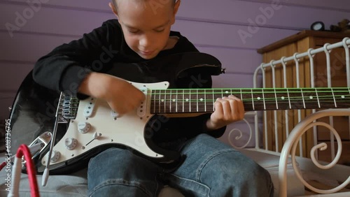 Little boy playing electric guitar and singing at home. 4k video footage UHD 3840x2160