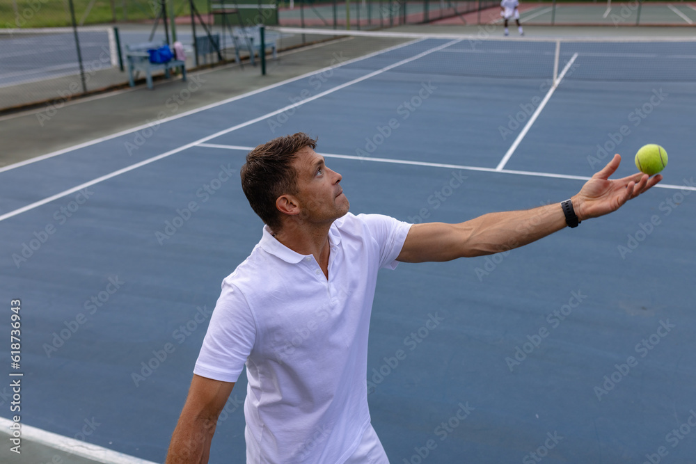© Wavebreak Media - Caucasian male tennis player playing tennis serving ball on outdoor court © Wavebreak Media - Caucasian male tennis player playing tennis serving ball on outdoor court