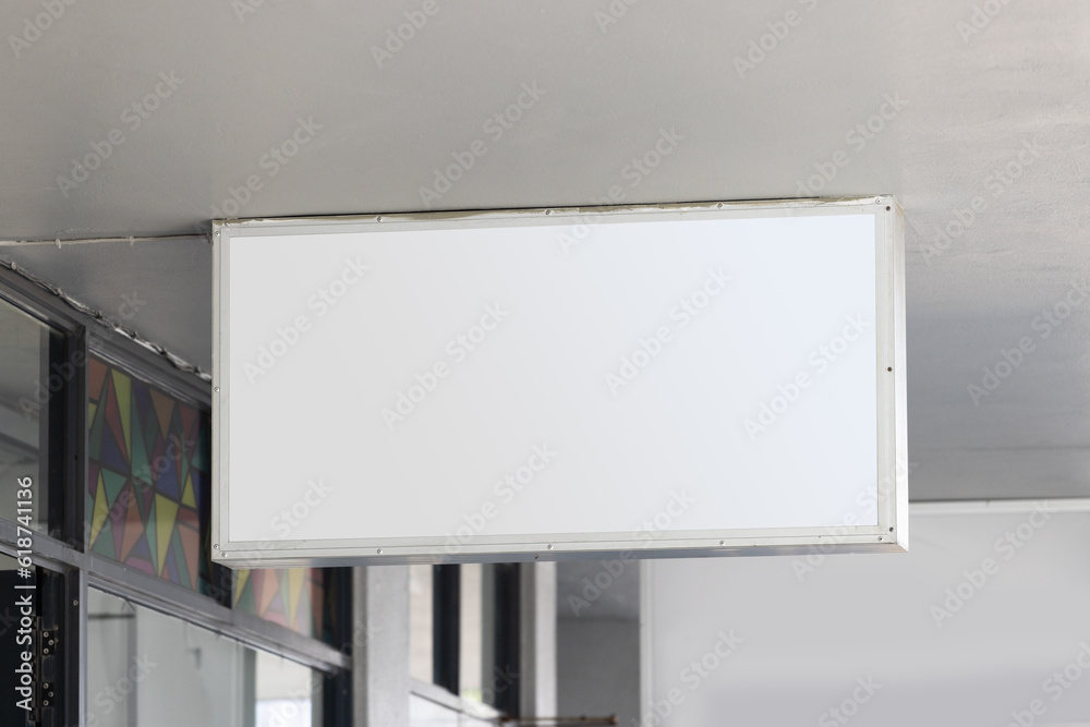 Blank sign hanging from building ceiling with copy space Blank sign hanging from building ceiling with copy space