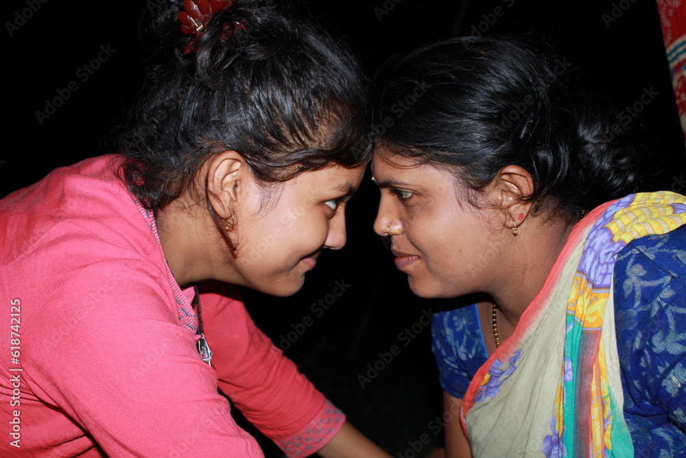 Fototapeta premium Two young beautiful Indian girl and woman on a black background.