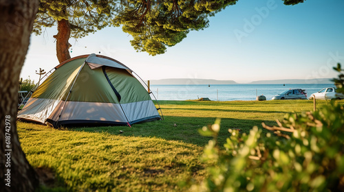 Selective focused on Lawn or green grass ground of camping ground near the sea beach. with camping tent in the background
