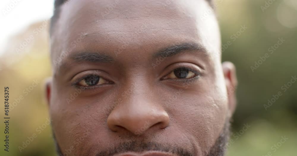 Portrait close up happy african american man smiling in garden, in slow motion Portrait close up happy african american man smiling in garden, in slow motion