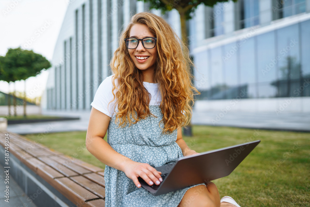 Obraz premium Young woman with wireless headphones calling on laptop, talk by webcam, video conference. Concept of education, online, business, blog or freelance.