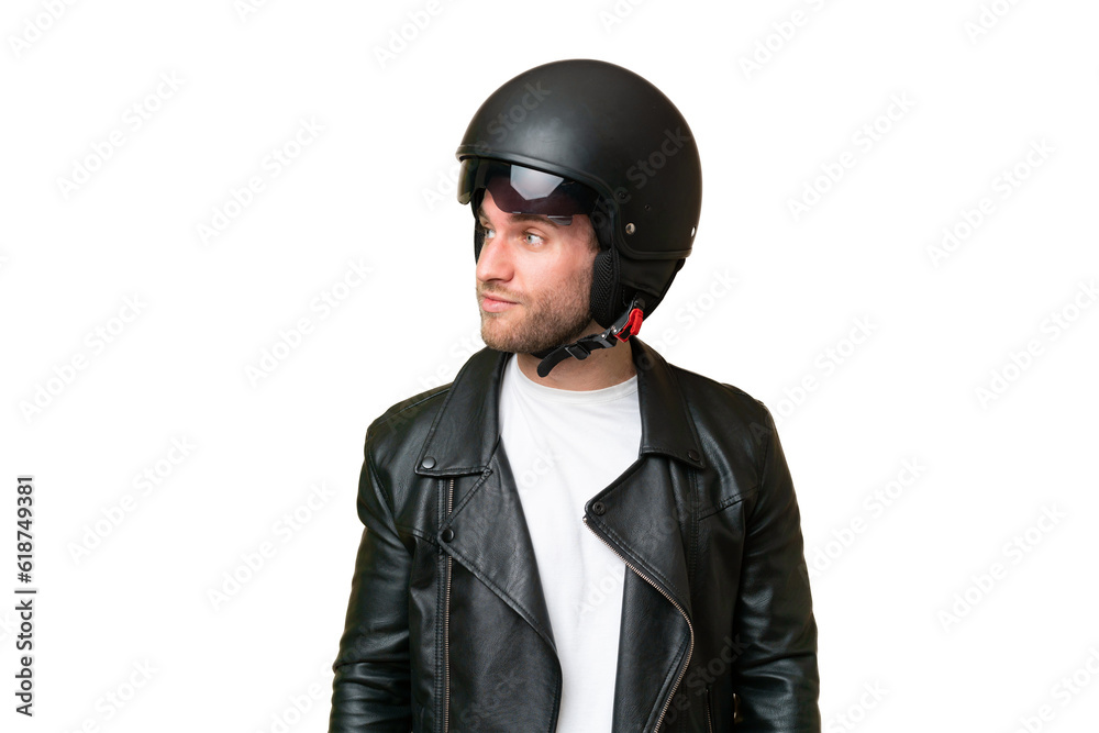 Young caucasian man with a motorcycle helmet isolated on green chroma background looking to the side Young caucasian man with a motorcycle helmet isolated on green chroma background looking to the side