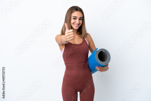 Young sport caucasian woman going to yoga classes isolated on white background with thumbs up because something good has happened © luismolinero