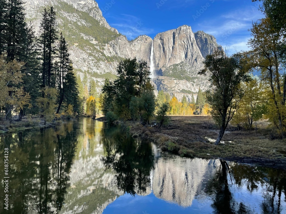 Naklejka premium Majestic Yosemite Valley surrounded by lush woodlands and towering mountain peaks