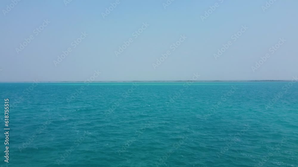 Aerial video of crystal clear water and a girl on the pier on the shore Aerial video of crystal clear water and a girl on the pier on the shore