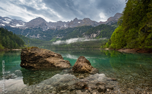 Lake Tovel in the Dolemites during a cloudy morning. Italy Travel. Hiking Destination. Landscape high quality. Beautiful Lake. photo