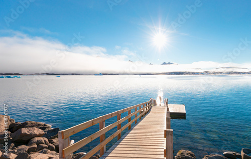 Midnight Sun concept with night time in the northern hemisphere - Tasiilaq wooden pier on coast - Greenland