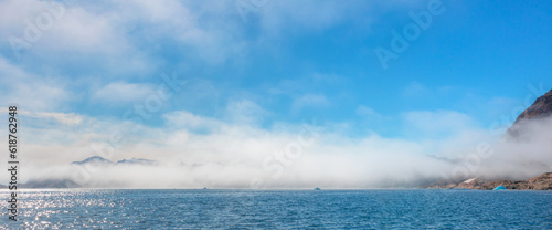 Arctic landscape of Greenland in Summer. Beautiful view of mountains with Snowy peaks and iceberg