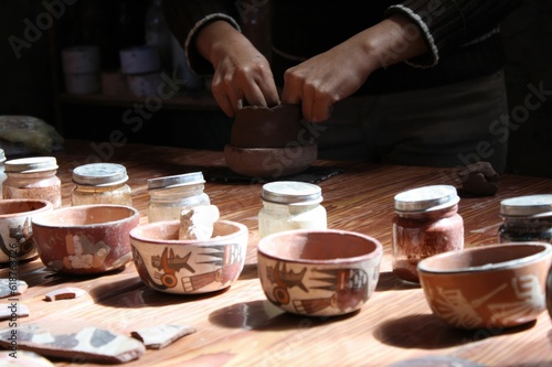 Wooden table with traditional Peruvian pottery samples.