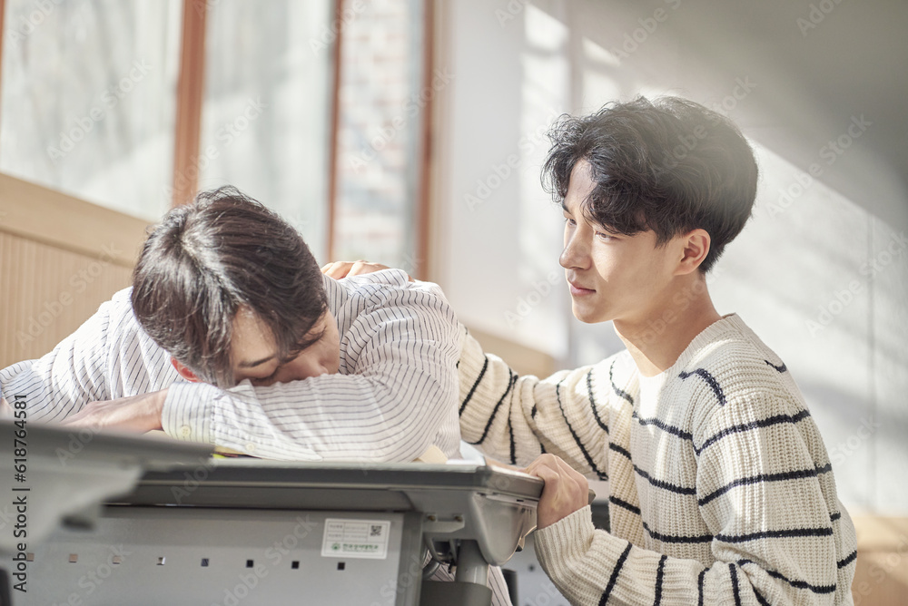 Obraz premium Young college student male model sleeping face down on a desk in a university classroom in Asia South Korea waking up boyfriend,colleague,motivation