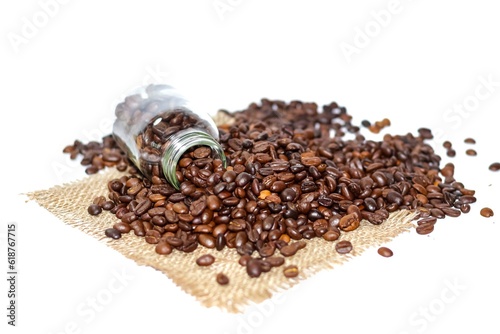 Coffee beans are spread over the white background and the coffee beans inside bottle with isolated picture.