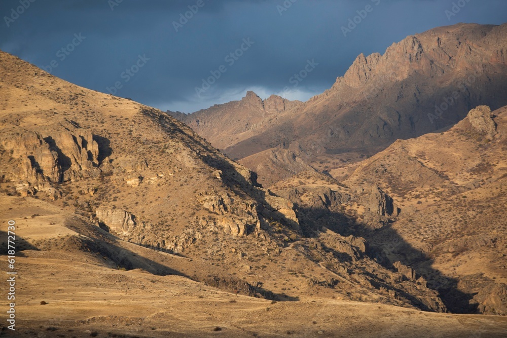 Fototapeta premium Scenic view of sunset over a mountain peak on a cloudy day