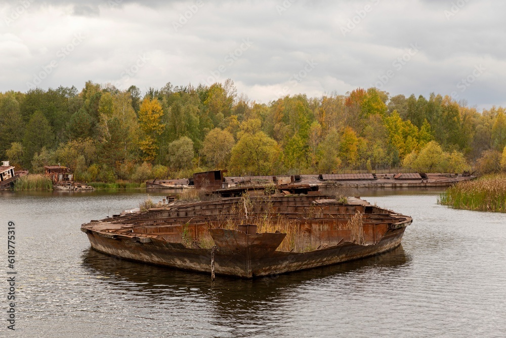 an old boat floating on a river in the fall season