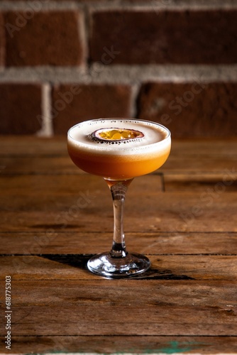 Exotic cocktail made with passion fruit, atop a wooden tabletop