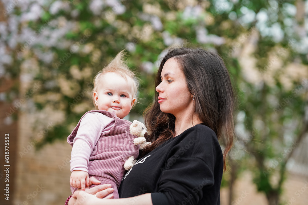 Mother gently hugs baby's little daughter outside Mother gently hugs baby's little daughter outside