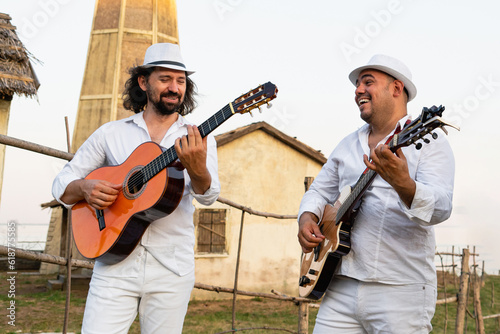 Musicians in white clothes and white hats play the guitars. © scharfsinn86