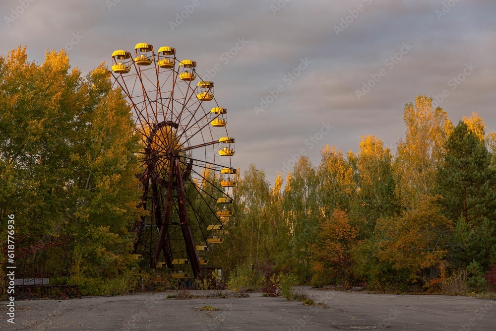a giant ferris wheel in an abandoned building in a wooded area