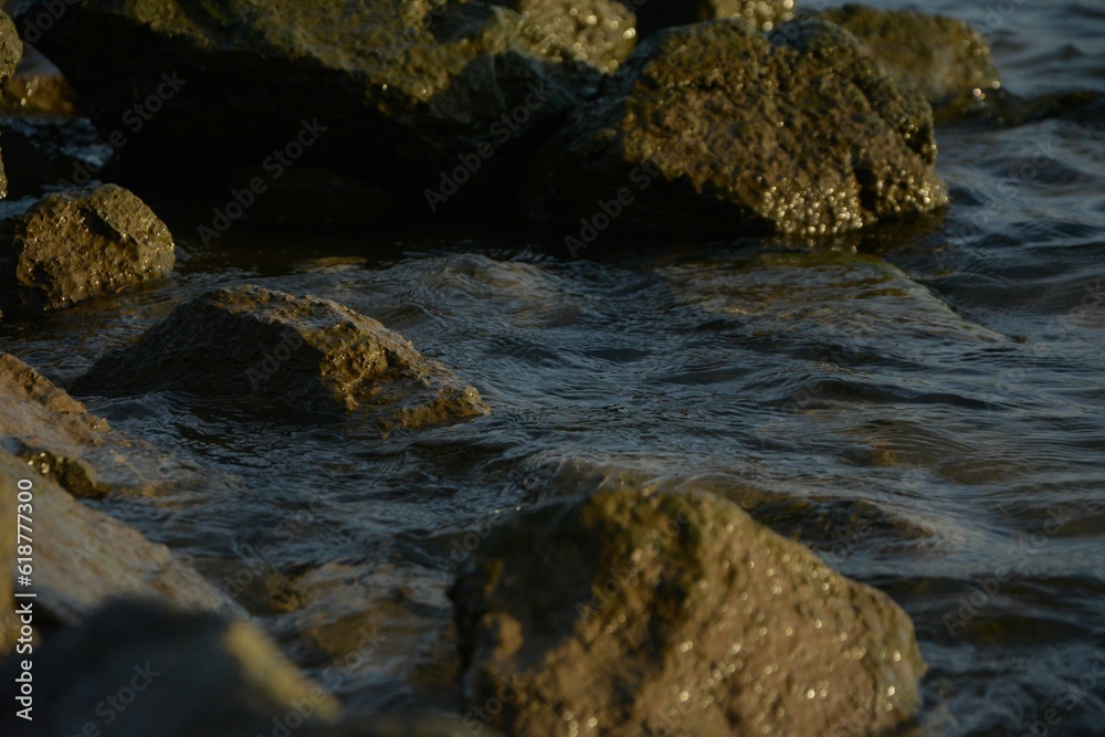 Rocks protruding out of the water with rippling waves lapping against them