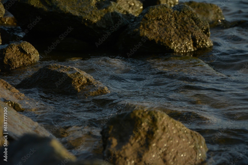 Rocks protruding out of the water with rippling waves lapping against them Rocks protruding out of the water with rippling waves lapping against them