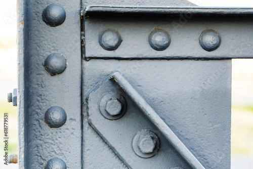 Fragment of an old metal structure with bolts and rivets. Close up