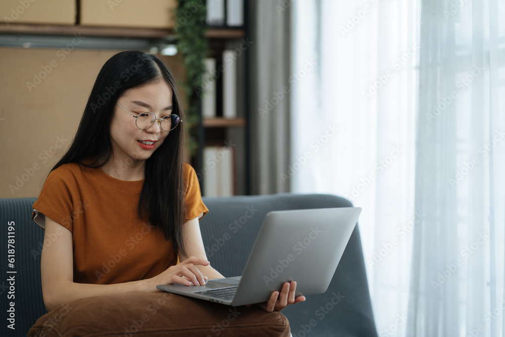 Women use laptop computers for laptop payments, online shopping, omni channels, sitting on sofa. Women use laptop computers for laptop payments, online shopping, omni channels, sitting on sofa.