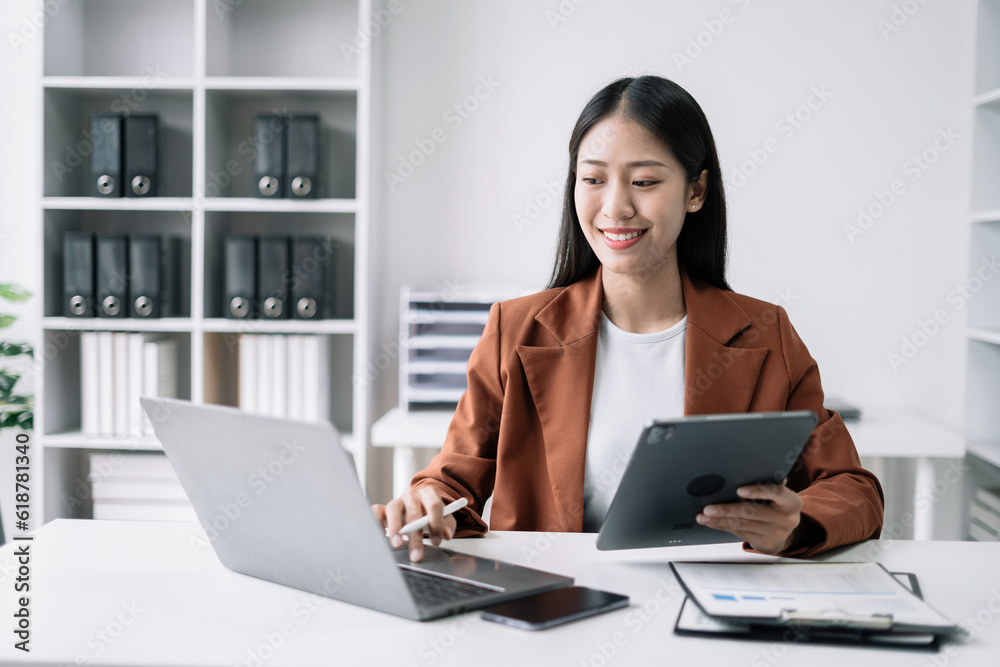 Businesswomen using tablet with laptop and document on desk in modern office. Businesswomen using tablet with laptop and document on desk in modern office.