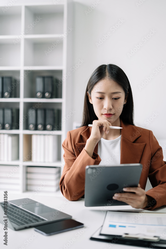 Business women hand working with tablet and laptop computer with documents on office desk in modern office. Business women hand working with tablet and laptop computer with documents on office desk in modern office.